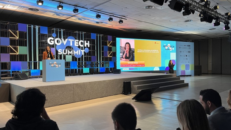 Foto da secretária no palco palestrando